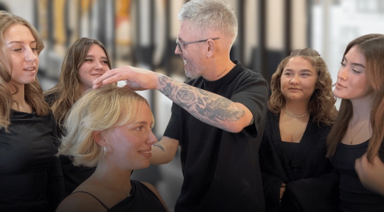 Noel demonstrating a cut to a small group of stylists